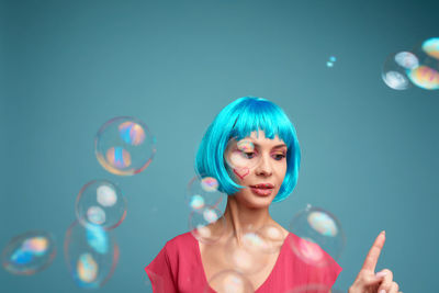 Portrait of young woman against wall