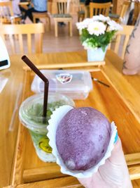 High angle view of hand holding ice cream on table