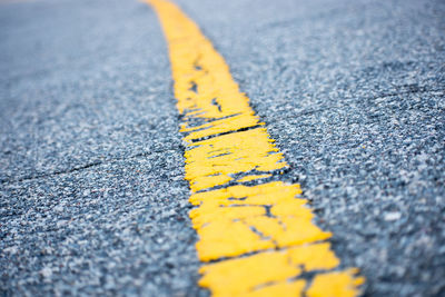 Close-up of yellow road sign on street