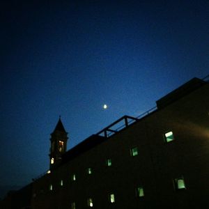 Low angle view of building against blue sky at night