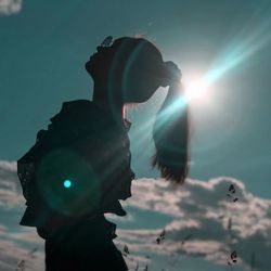 Man holding illuminated lighting equipment against sky