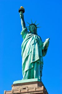 Low angle view of statue against blue sky