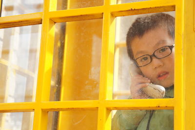 Portrait of young man looking through window