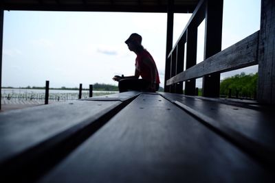 Surface level view of woman sitting on bench