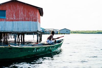 Man on boat in sea against clear sky