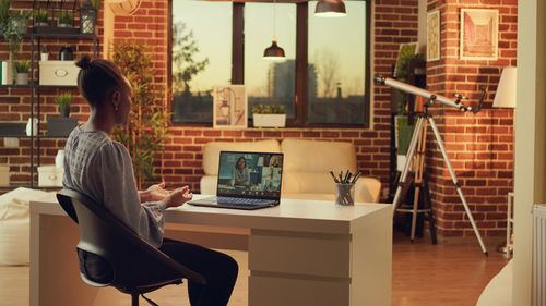 Side view of woman using digital tablet while sitting on table