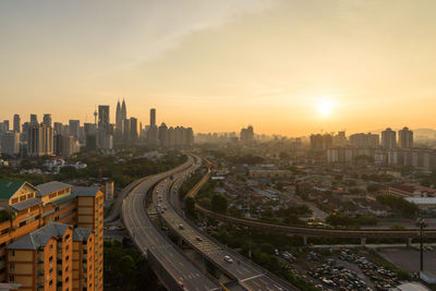 High angle view of bridges in city at sunset