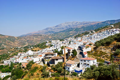 Buildings in town against clear blue sky