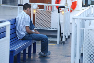 Side view of young man sitting on seat