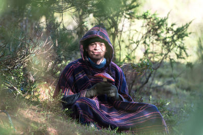 Colombian native american man in traditional clothing presenting mushroom