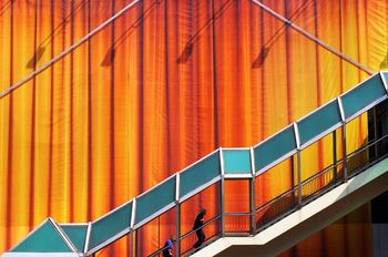 Elevated walkway against large orange curtains