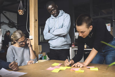 Female freelancer discussing with coworkers over strategy at workplace