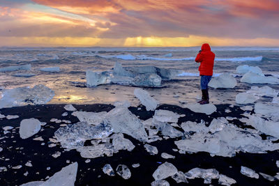 Full length of man standing on beach during sunset