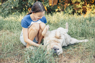 Side view of boy with dog on grassy field
