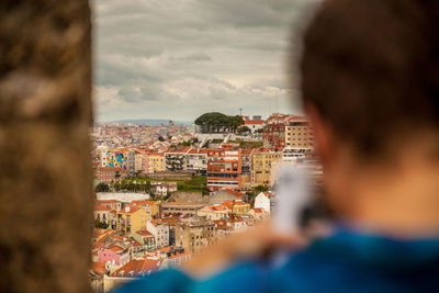 Rear view of man on cityscape against sky