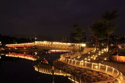 Illuminated bridge over river at night