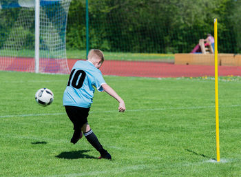 Full length of man playing soccer ball on field