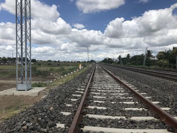 Railroad tracks on field against sky