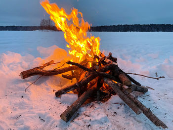 Bonfire on wooden log on field during winter