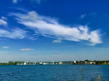 Scenic view of sea by buildings against sky