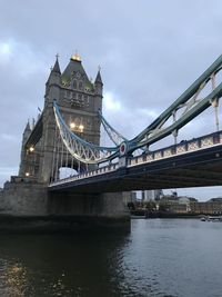 View of bridge over river against cloudy sky