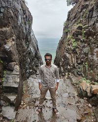 Portrait of young man standing on rock