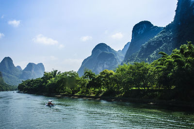 Scenic view of river and mountains against sky