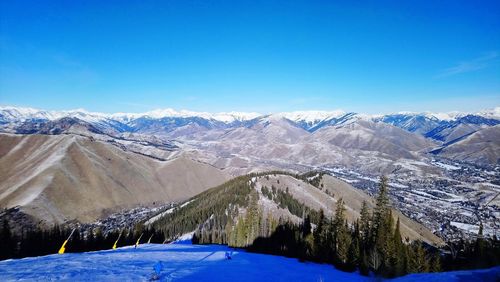 Scenic view of snowcapped mountains against blue sky