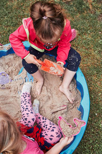 High angle view of girls playing with sand in park