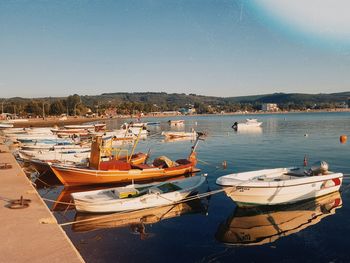 Boats moored in lake against clear sky