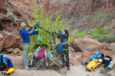People hang wet clothes on tree at camp on escalante river, utah