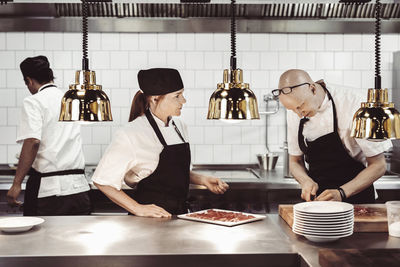 Male and female chefs working in commercial kitchen