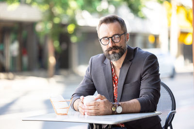 Happy middle age businessman portrait drinking a coffee outdoors in bangkok, thailand. person