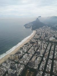 High angle view of buildings and sea against sky