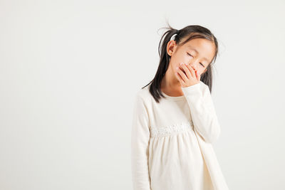 Young woman standing against white background