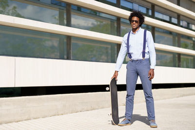 Portrait of young man standing against wall