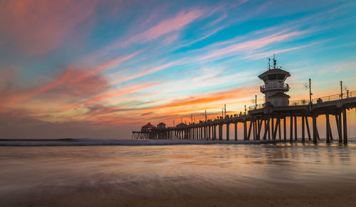 Pier over sea against sky during sunset