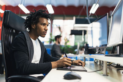 Man looking at camera while sitting on table