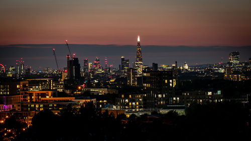 Illuminated cityscape against sky at night