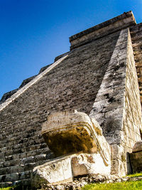 Low angle view of old ruin building against blue sky