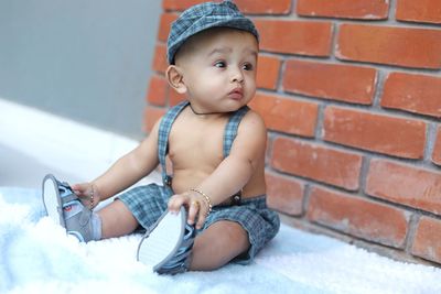 Cute baby girl sitting on wall