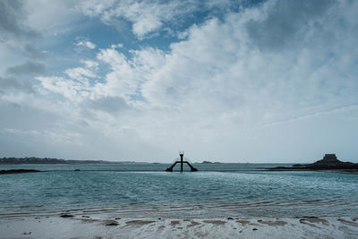 Scenic view of sea against sky. swimming pool on natural beach with jumping tower.