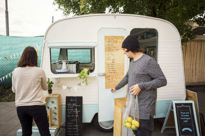 Male and female owner working outside food truck on street