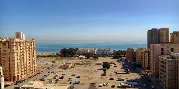 High angle view of buildings by sea against sky