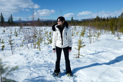 Woman standing on snow covered landscape
