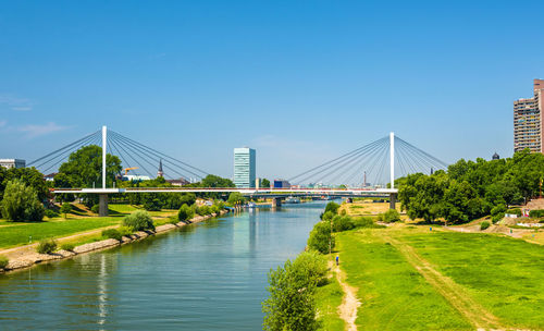 Bridge over river in city against sky