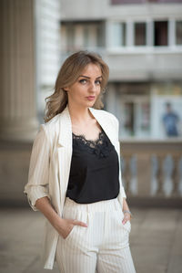 Beautiful young woman standing against the wall