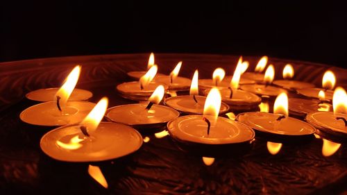 Close-up of lit candles in temple