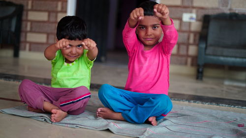 Indian little boy is smiling while doing yoga in hall at home. worldwide yoga day concept.
