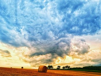 Hay bales on field against sky